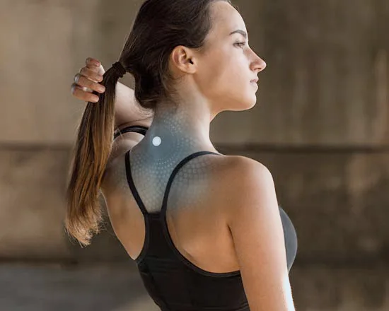 Woman with ponytail in athletic top, showing a LifeWave patch applied to her neck with an energy field graphic.